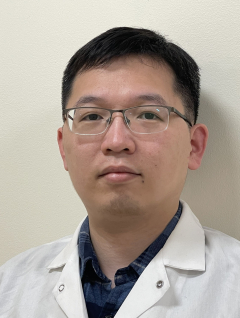 a man in a lab coat smiling for a picture