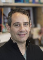a man in a lab coat smiling for a picture